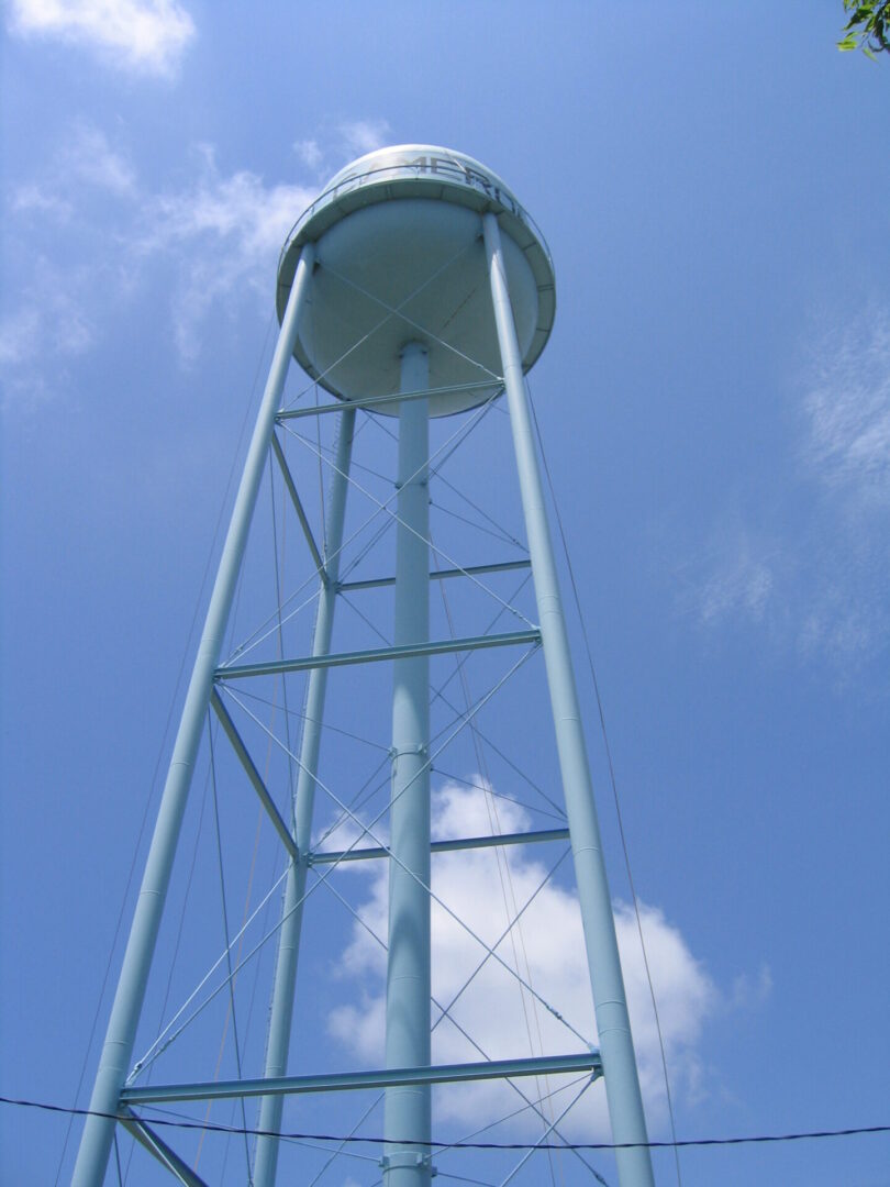 Tall blue water tower against clear sky